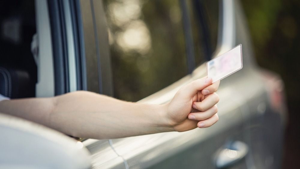 Close,Up,Person,Hand,Out,Of,The,Car,Window,Holding