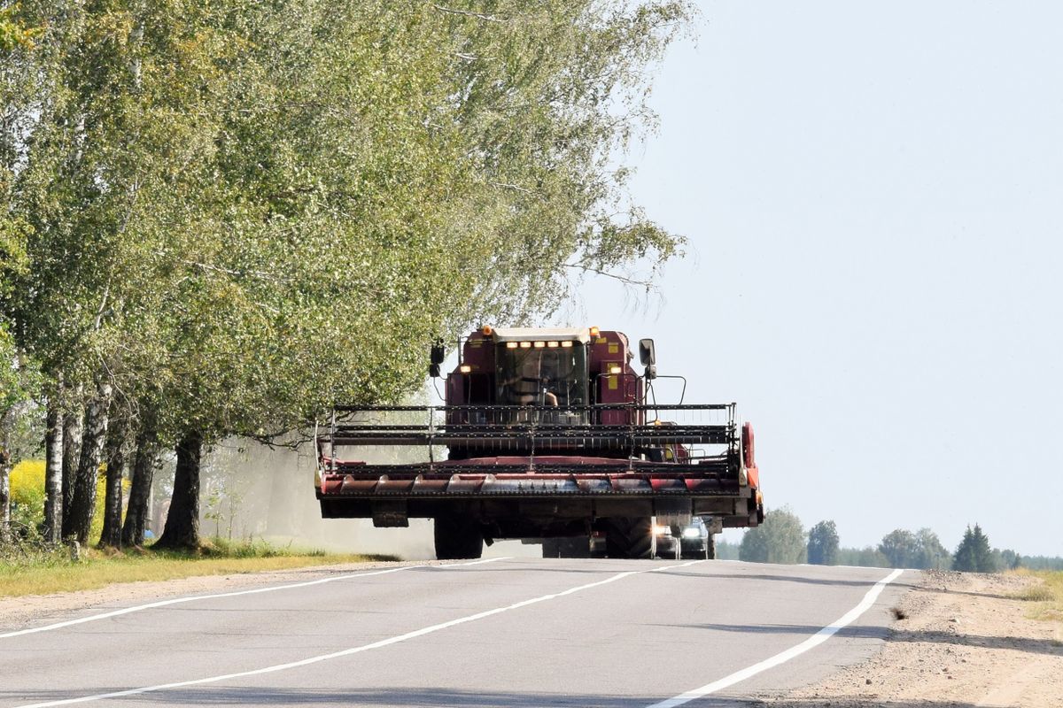 Modern,Combine,Harvester,Moves,In,A,Column,By,Road