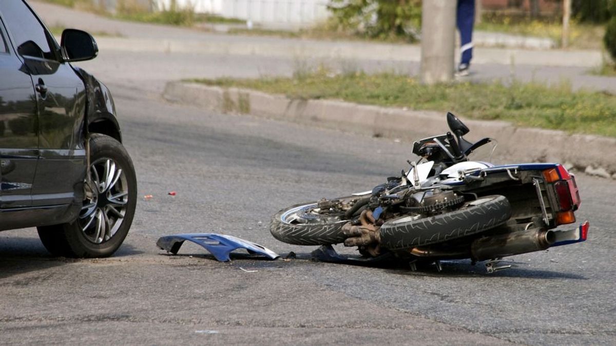 Motoros rohant bele autóba