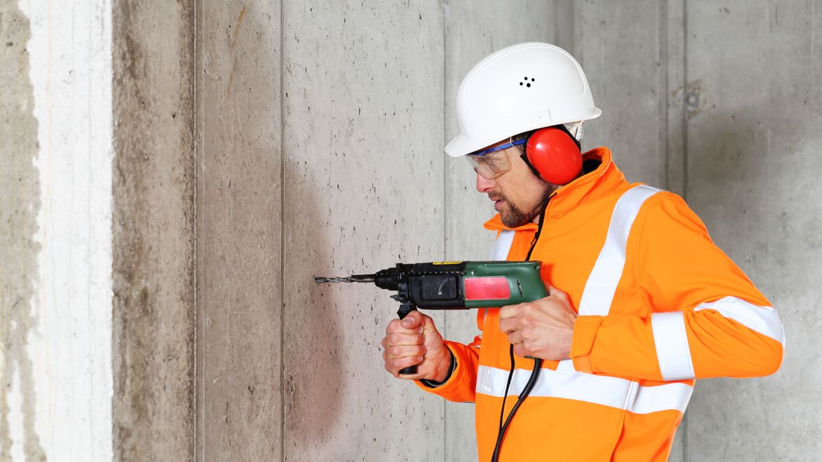 A,Worker,Man,Drilling,In,Concrete,On,A,Construction,Site